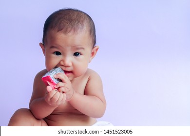 Asian Cute Baby Girl Eating Red Dragon Fruit. Newborn Baby On White Background