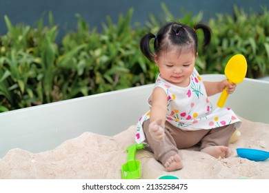 Asian Cute Baby Playing Sand In Sandbox At Outdoor. 1 Year 6 Month Baby Enjoy To Play Sand Use As Concept Of Play, Health, Mood And Motion Of Baby And Kid Development.