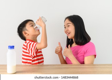 Asian Cute Boy Drinking Milk With His Mother, White Wall At Home, .Food And Drink Concept With Copy Space