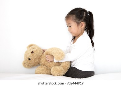 Asian Cute Little Girl Playing Doll Teddy Bear In The Bedroom