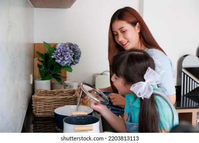 Asian Cute Mom Teach Daughter Cooking Food In Kitchen At Home For Family Day. Funny And Smiling Together. Smell And Test Good.