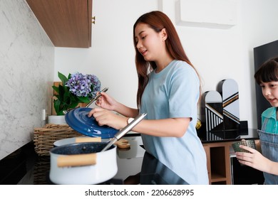 Asian Cute Mom Teach Daughter Cooking Food In Kitchen At Home For Family Day. Funny And Smiling Together. Smell And Test Good.