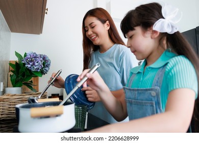 Asian Cute Mom Teach Daughter Cooking Food In Kitchen At Home For Family Day. Funny And Smiling Together. Smell And Test Good.