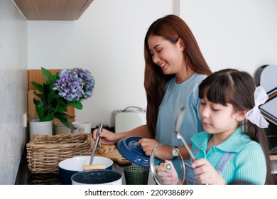 Asian Cute Mom Teach Daughter Cooking Food In Kitchen At Home For Family Day. Funny And Smiling Together. Smell And Test Good.