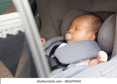 Asian Cute Newborn Baby Sleeping In Modern Car Seat. Child New Born Traveling Safety On The Road. Safe Way To Travel Fastened Seat Belts In A Vehicle With Young Kids. Trip With An Infant.