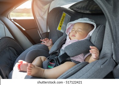 Asian Cute Newborn Baby Sleeping In Modern Car Seat. Child New Born Traveling Safety On The Road. Safe Way To Travel Fastened Seat Belts In A Vehicle With Young Kids. Trip With An Infant.