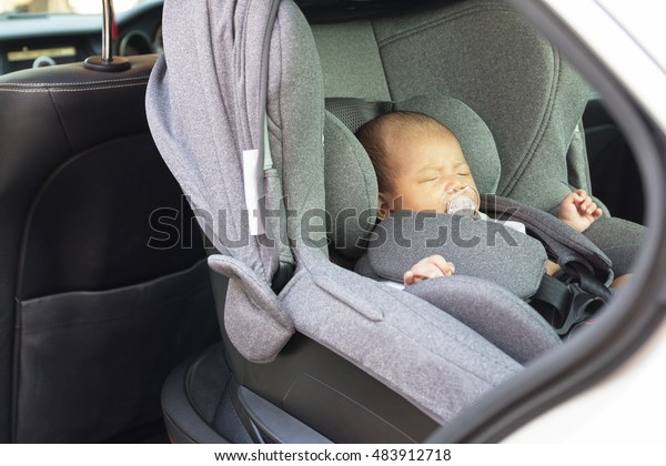Asian cute one\
month old newborn baby sleeping in modern car seat. Child new born\
traveling safety on the road. Safe way to travel fastened seat\
belts in a vehicle with young\
kids.