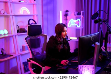 Asian cute player woman thinking strategy game plan about support team for win in pink neon light room at apartment - Powered by Shutterstock