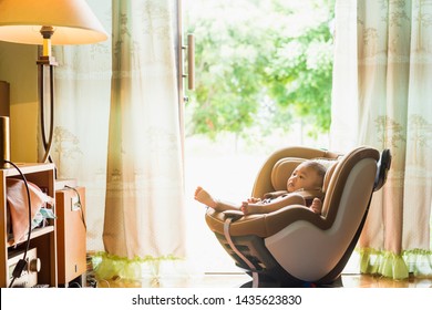 Asian Cute Six Months Old Newborn Baby  Relax And Happy Until Testing Car Seat Indoor With Green Of Nature Background. Child New Born Traveling Safety On The Road Like As In Home.