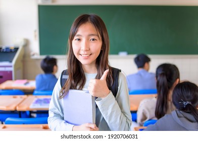 asian cute student teenager girl showing thumbs up in  classroom - Powered by Shutterstock