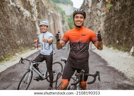 asian cyclist showing thumb up and smile to camera