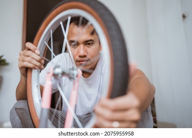 Asian Dad Puts On A Wheel While Assembling A Bike