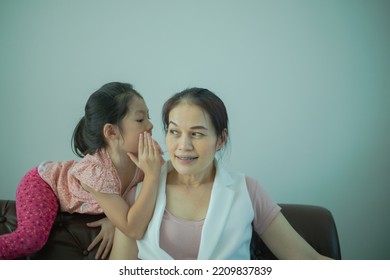 Asian Daughter Girl Whispering To Mother A Secret.