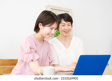 Asian Daughter Using The Laptop With Her Mother At Home