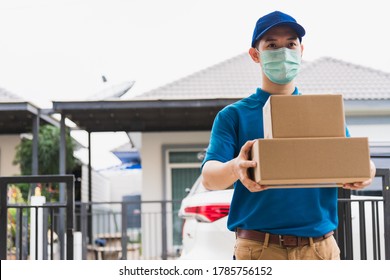 Asian delivery express courier young man giving boxes to woman customer he wearing protective face mask at front home, under curfew quarantine pandemic coronavirus COVID-19