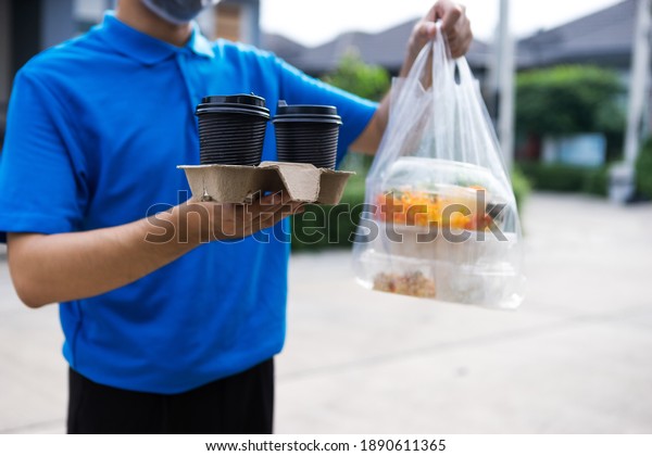 Asian delivery man delivering food, fruit, juice
and vegetable to customer home - online grocery shopping service
concept