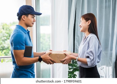 Asian Deliveryman Delivering Package Box Parcel Giving To Female Customer At Home Delivery Service Logistics Business Ordering Mail Posting Business At Front Door Of House Wearing Formal Uniform 