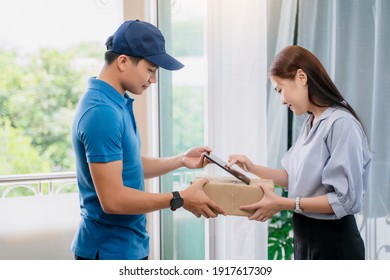 Asian Deliveryman Delivering Package Box Parcel Giving To Female Customer Signing Using Smart Technology Tablet At Home Delivery Service Logistics Business Ordering Mail Posting Front Door Of House 