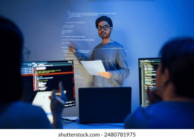 asian developer leads present code review session, pointing at code projected on the wall with colleagues  teamwork and knowledge sharing in software development. - Powered by Shutterstock