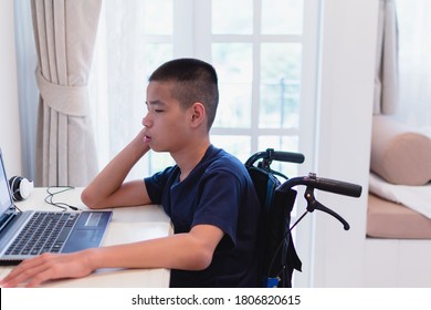 Asian disable child on wheelchair happy time to use a notebook in the house, Study and Work at home for safety from covid 19,Life in the education age of special need kid,Happy disability boy concept.