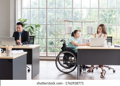 Asian Disabled Business Woman Woking Together With Her Colleague At Workplace