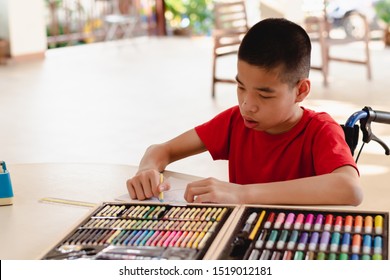 Asian disabled child on wheelchair coloring art work,The skills to practice muscle development,Special children's lifestyle,Life in the education age of special need kids,Happy disability kid concept.