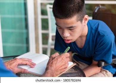 Asian Disabled Child On Wheelchair Learning In Homeschool And Father, New Normal Study At House By Parent, Life In The Education Age Of Special Need Kid, Happy Disability Boy And Home School Concept.