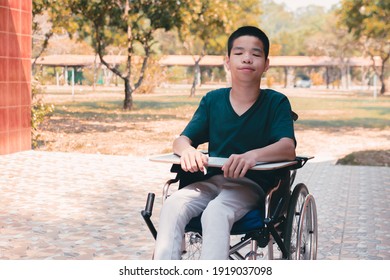 Asian Disabled Child On Wheelchair And Trays For Activities With Disabilities People,Skills To Practice Muscle Development, Special Children's Lifestyle,Life In The Education Age Of Special Need Kids.