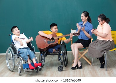 Asian Disabled Children And Woman Teacher Enjoying And Playing Guitar 