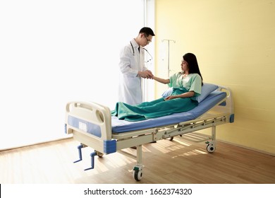 Asian Doctor Checkup And Pulse Measurement Of Patient Women With Long Black Hair Who Lying On Bed In Hospital And Recommend Treatment And Remedy Illness And Dispense. Bangkok Thailand South East Asia