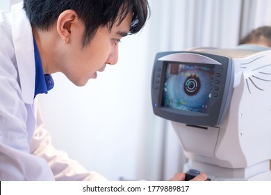 Asian doctor controls the oculist display with a scanned eye, diagnostic ophthalmology equipment