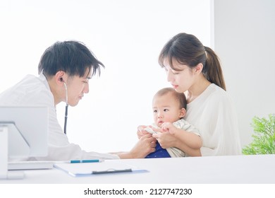 Asian doctor examining Asian baby.