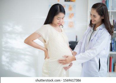 Asian doctor is examining the pregnant woman