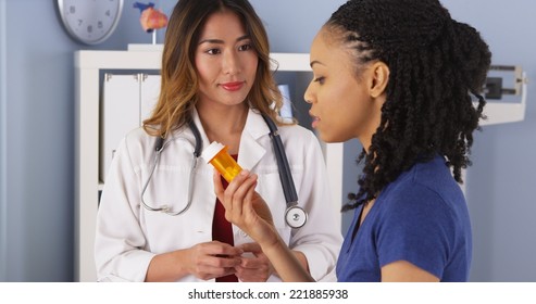 Asian Doctor Explaining New Prescription To Black Patient