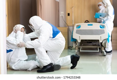 Asian Doctor And Medical Technicians In Protective Disease PPE Suit Uniform And Face Mask Sad, Tire And Despair. Medical Staff In Clean Suit. 