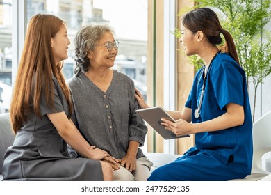 Asian Doctor or Nurse Talking to Senior Patient and Daughter in Hospital or clinic, showing Medical Results on Digital tablet, Medicine and health care - Powered by Shutterstock