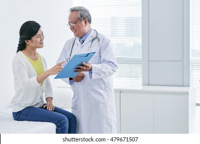 Asian Doctor And Patient Discussing Diagnosis Or Prescription