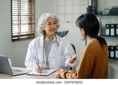 Asian Doctor and patient discussing something while sitting at the table . Medicine and health care concept. 

 - Powered by Shutterstock