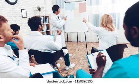 Asian Doctor Shares Experience With Colleagues. Paper Desk Information. Professional Medical Consultation. Multinational Medician Meeting. Teamwork Connection. Clinician Team Group.