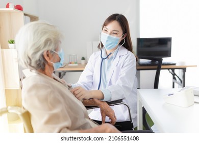 Asian doctor talk with old female patient about disease symptom, doctor use stethoscope listening lung of patient, elderly health check up , they wear surgical mask on white background, corona virus 