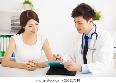 Asian Doctor Talking With Female Patient In  Office