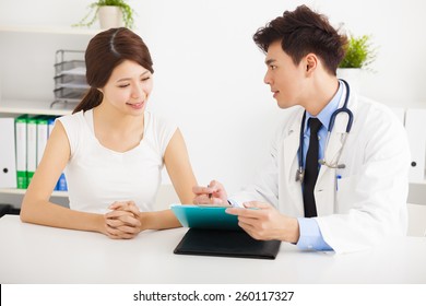 Asian Doctor Talking With Female Patient In  Office