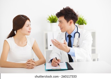 Asian Doctor Talking With Female Patient In  Office