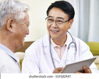 Asian Doctor Talking To A Senior Patient, Happy And Smiling