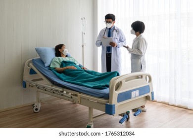 Asian Doctor Teaching Medical Student Who Wearing Face Mask To Treat Sick Patient In The Ward In Hospital. Healthcare And Medical And Nursing School Concept