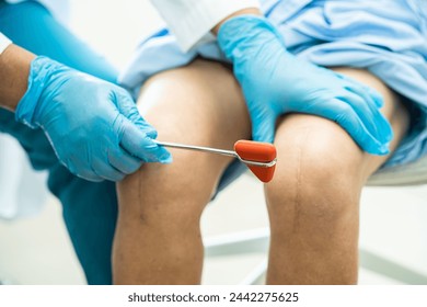 Asian doctor use hammer knock senior woman patient to check knee reflex, nerve and muscle in hospital. - Powered by Shutterstock