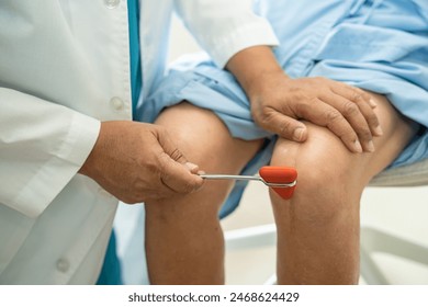 Asian doctor use hammer knock senior woman patient to check knee reflex, nerve and muscle in hospital. - Powered by Shutterstock