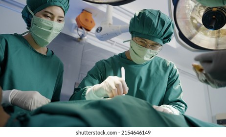 Asian Doctor Uses A Scalpel To The Patient With Surgical Team In Operating Room