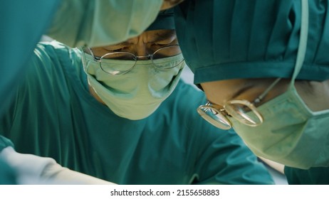 Asian Doctor Uses A Scalpel To The Patient With Surgical Team In Operating Room