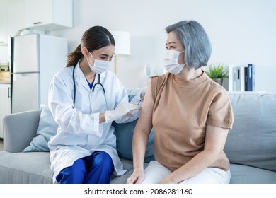 Asian Doctor Wear Mask, Give Treatment To Senior Elderly Woman Patient. Beautiful Therapist Specialist Nurse Holding Injection Syringe And Squirting Vaccine For Older Grandmother At Nursing Home Care.
